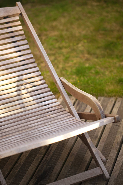 Wooden deck chair on a terrace in a garden - Foto, imagen