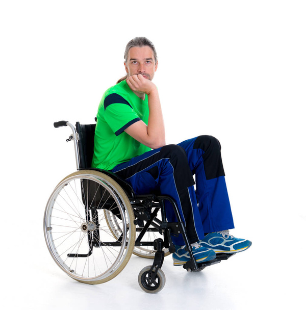 young man in a wheelchair in front of white background is sad - Фото, зображення