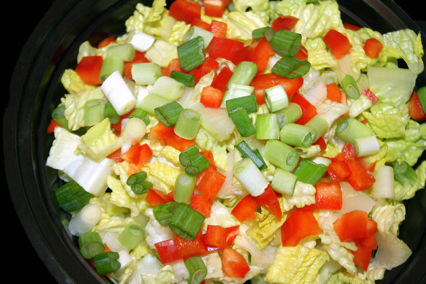 Salade de jardin fraîche avec laitue romaine hachée, poivrons rouges coupés en dés et oignons verts
 - Photo, image