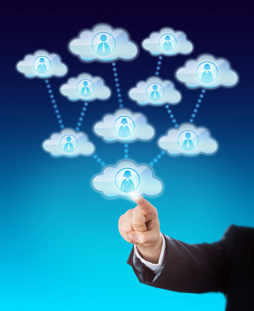 Arm of a business man accessing the support of many knowledge workers. His index finger is touching a cloud icon that is linked to several other clouds. Metaphor for cloud sourcing and scalability. - Photo, Image