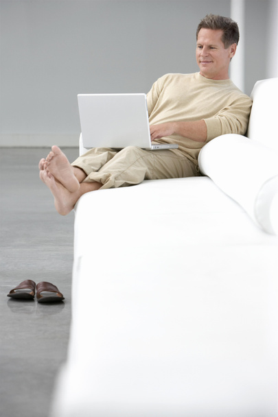 Muž používající notebook na pohovce - Fotografie, Obrázek