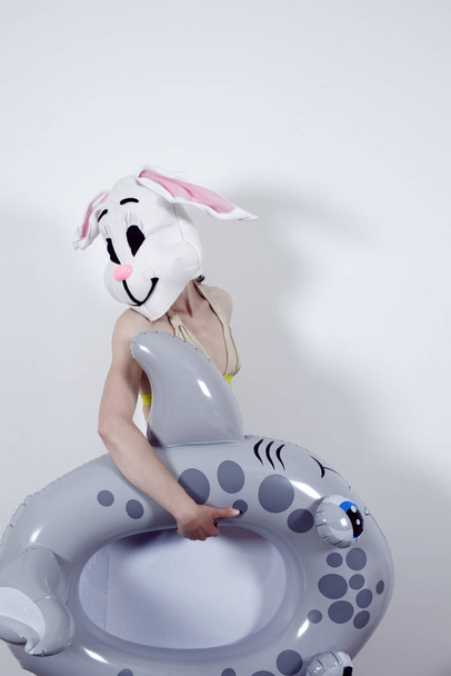 Rabbit woman playing with an inflatable shark - Фото, изображение