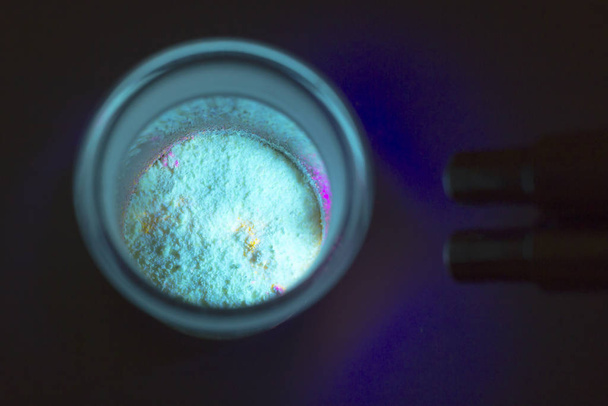 fluoreszierende organische Materialien von roter, gelber und grüner Farbe für die Produktion oled innerhalb Glasflasche in UV-Licht. - Foto, Bild
