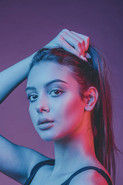 Photo tinted. Gorgeous brunette with plump natural lips. Portrait of a girl in the studio with color filters. - Foto, afbeelding