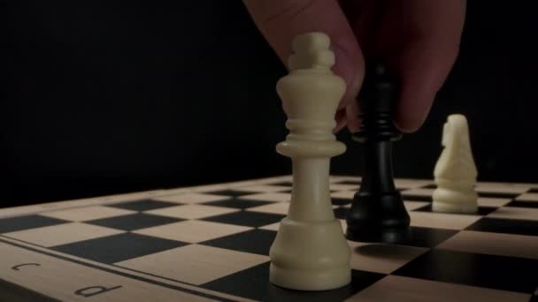 Σκάκι. Μαύρος παίκτης βάζει ματ στον λευκό βασιλιά. Ο βασιλιάς έπεσε. - Πλάνα, βίντεο