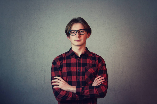Positive teenage guy hipster, wearing casual red shirt and glass - 写真・画像