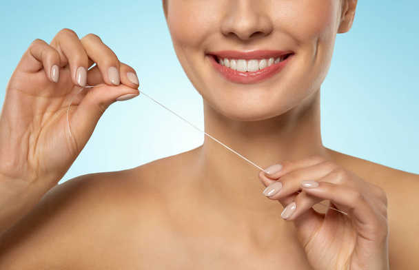 smiling woman with dental floss cleaning teeth - Photo, Image