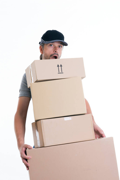 overstrained postman with parcels in front of white background - Photo, Image