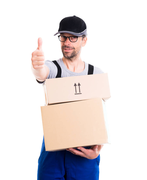 friendly postman with cap and parcels and thumb up - Foto, afbeelding