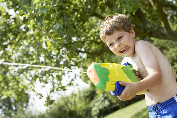 Boy shooting with water pistol - Photo, Image
