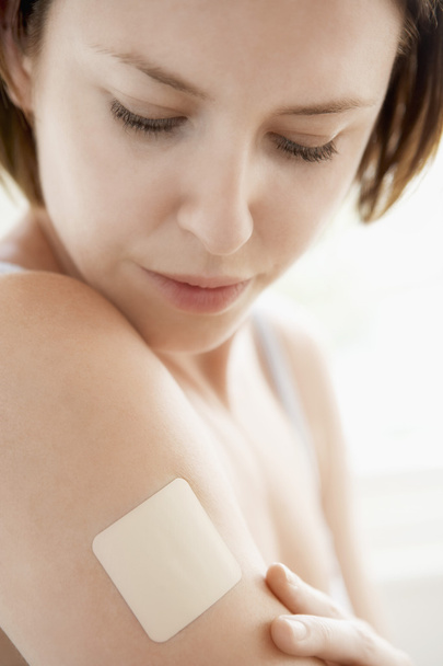 Woman looking at nicotine patch - Foto, Imagen