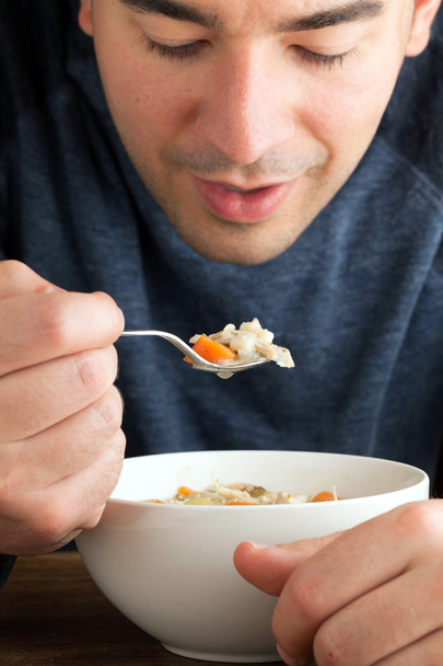 Homme mangeant de la soupe de poulet
 - Photo, image