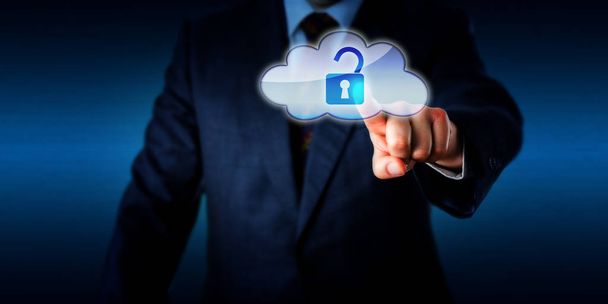 Torso of a businessman opening a virtual padlock in the cloud via touch. Technology metaphor for cloud computing, information access and network security. Plenty of copy space. Brick wall background. - Photo, image