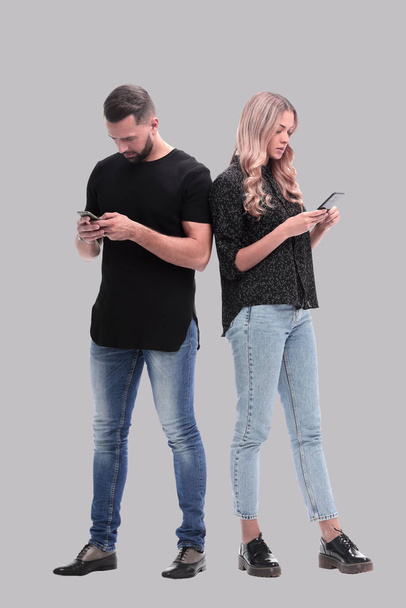 loving young couple reading e-mails on their smartphone - Фото, изображение