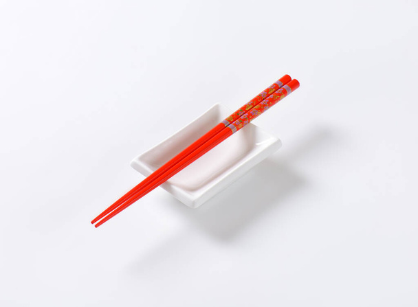 pair of red chopsticks and white bowl on white background - Fotografie, Obrázek