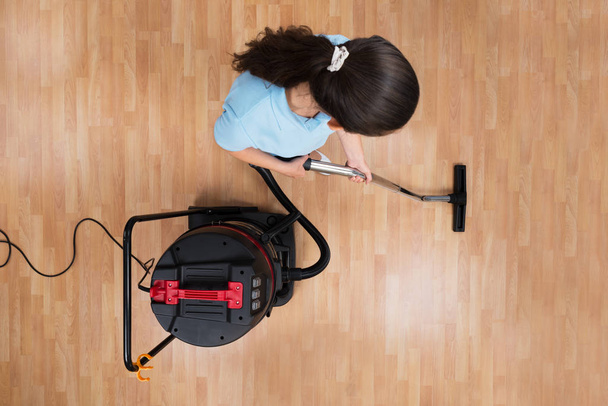 High Angle View Of Young Woman Cleaning Floor With Vacuum Cleaner - Valokuva, kuva