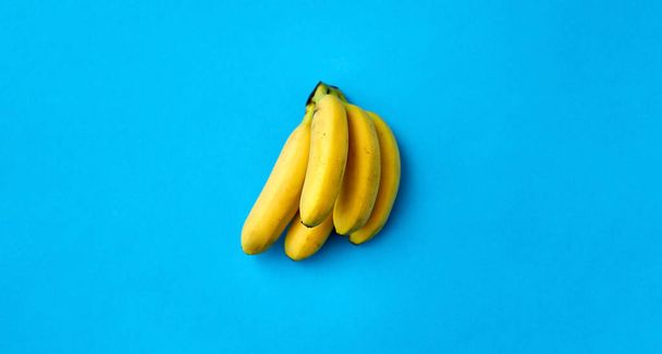 close up of ripe banana bunch on blue background - Фото, зображення