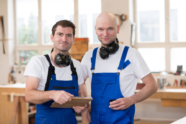 two men in workwear in a carpenter's workshop - Fotografie, Obrázek