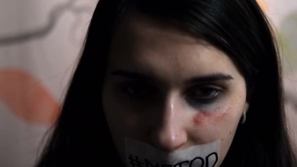 暴力の若い女性の犠牲者は彼女の頭を上げ、彼女の顔に「 metoo 」という言葉を示します. - 映像、動画