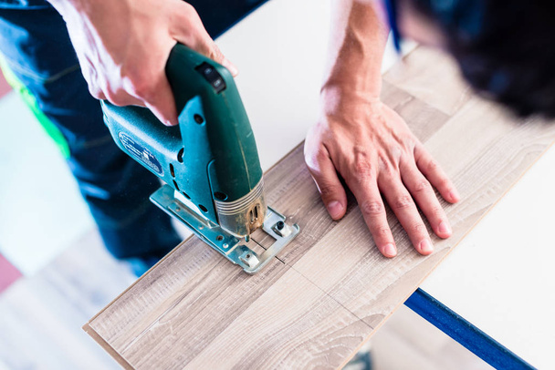 handyman cut wood floor with jigsaw - Foto, immagini
