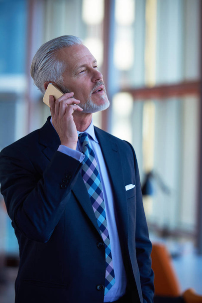 senior business man talk on mobile phone  at modern bright office interior - Foto, Bild