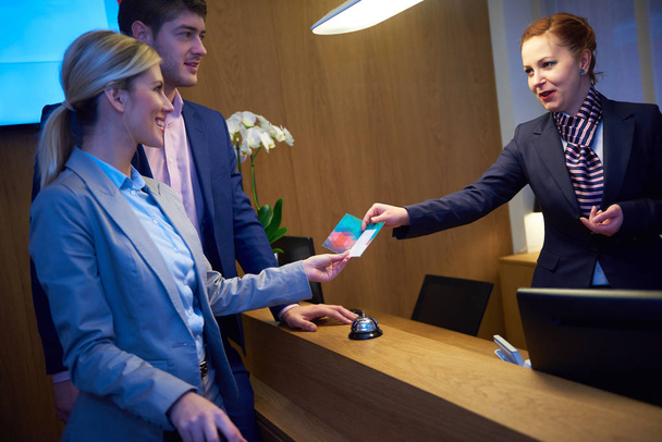 Couple on a business trip doing check-in at the hotel - Фото, изображение