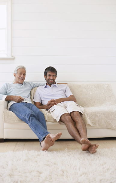 Father and Son Sitting on Sofa - Photo, image