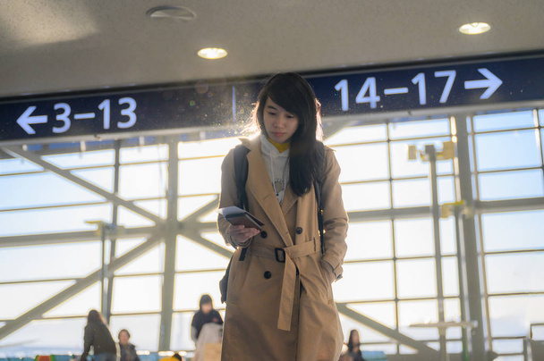 kobieta pasażer idzie do terminalu bramy wjazdowej na lotnisku, gotowy do odprawy w hali licznika kart pokładowych  - Zdjęcie, obraz