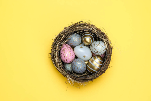 Feliz Pascua huevos fondo amarillo. Huevos decorados con brillo dorado en cesta, para tarjeta de felicitación, promoción, póster
 - Foto, Imagen