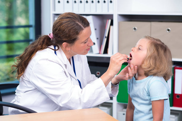 female pediatrician in white lab coat examined little girl - Valokuva, kuva
