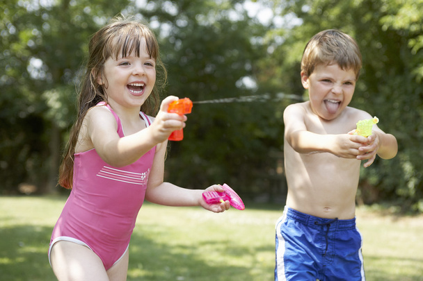 Girl and boy with water pistols - Zdjęcie, obraz