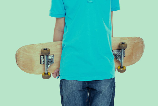 menino em vestido azul com skate na frente do fundo branco
 - Foto, Imagem