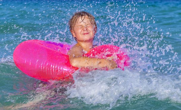 Junge im Schwimmring hat Spaß im Ozean - Foto, Bild