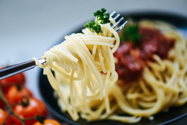 Espaguetis sobre tenedor y espaguetis pasta italiana boloñesa con par
 - Foto, imagen