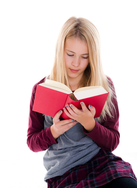 jovencita rubia leyendo un libro frente a fondo blanco - Foto, Imagen