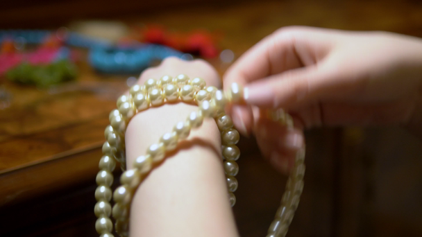 jeune fille enlève des perles blanches avec ses mains. gros plan
 - Séquence, vidéo