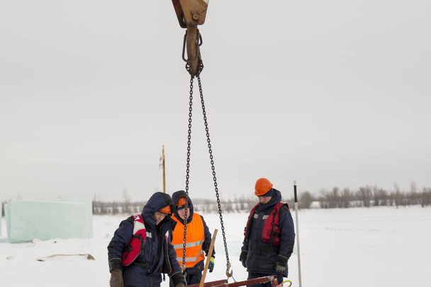 Trabalhadores pegam blocos de gelo na pista
 - Foto, Imagem
