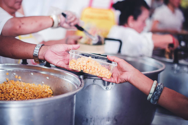 Концепція нестачі продовольства, голодні люди пропонують пожертви на харчування від волонтерів, які пожертвували безкоштовною благодійною їжею
. - Фото, зображення