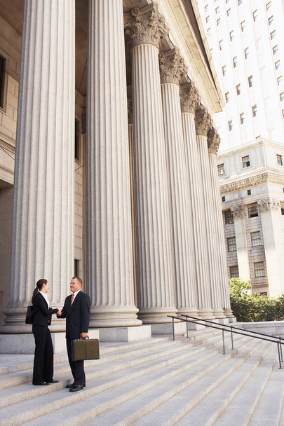 Attorneys shaking hands on courthouse steps - Fotó, kép