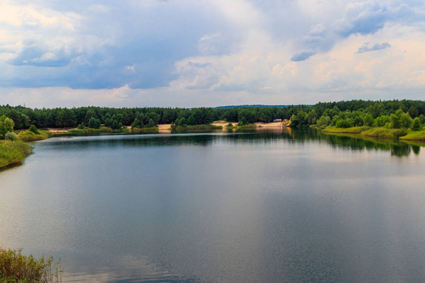 Vista de un hermoso lago en un bosque de pinos en verano - Foto, imagen
