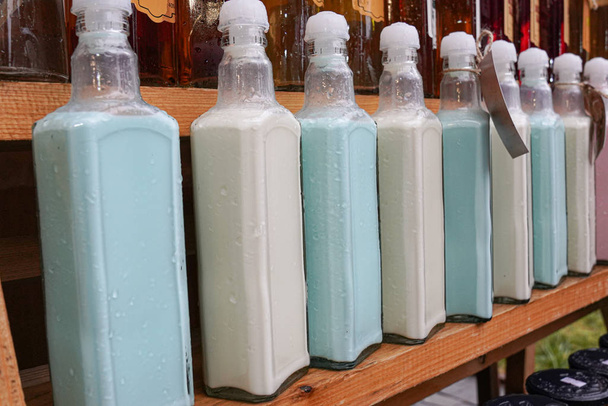 Close up of the pink and blue craft yogurt in glass bottles - 写真・画像