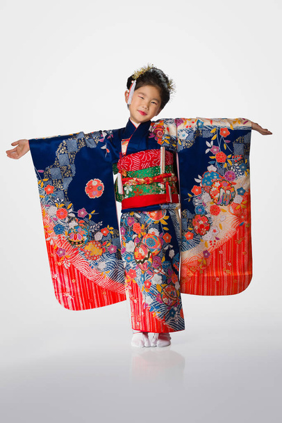 A cute young Japanese girl wearing a Kimono on a white background. - Fotografie, Obrázek