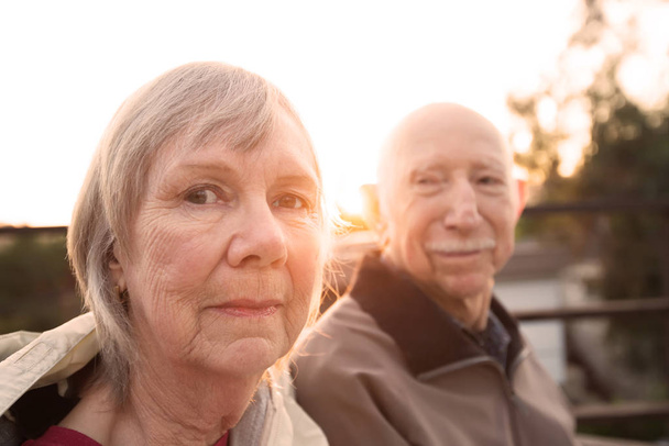 Calm Caucasian senior couple sitting together outdoors - Фото, изображение