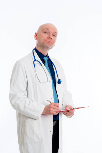 przyjazny młody lekarz z schowkiem przed białym tle - Zdjęcie, obraz