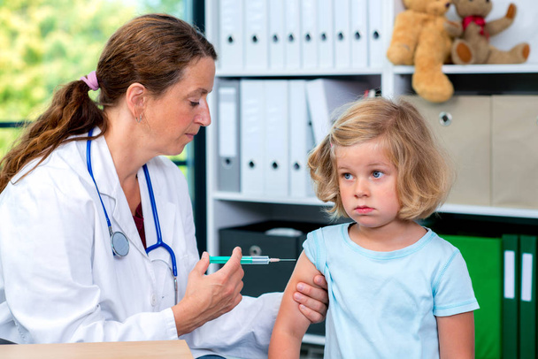female pediatrician in white lab coat injected a medicament - Foto, Bild