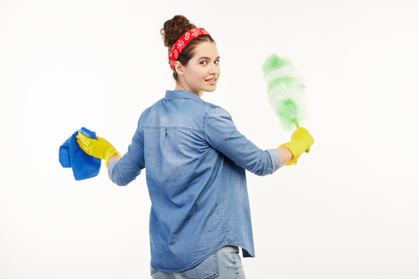 Pretty woman in work-wear uses dust cleaning supplies. - Фото, зображення