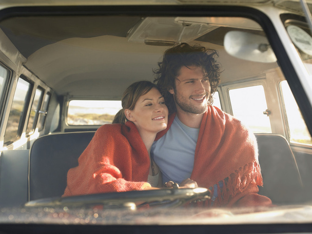 Couple wrapped in blanket in van - Photo, Image
