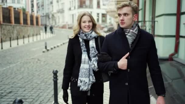 elegantti kaunis blondi pari kävelee kaupungin kadulla, katsoen toisiaan hymyillen ja suudellen
 - Materiaali, video