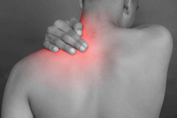 Plan noir et blanc de l'homme du dos ayant une tache rouge de douleur et un traumatisme au cou
. - Photo, image