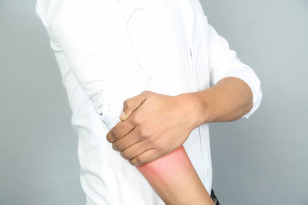 Homme portant une chemise blanche souffrent de douleur au bras
. - Photo, image